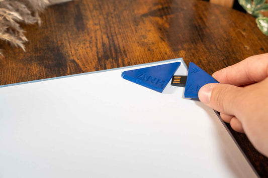 Blauer USB-Anhang klebend in Bachelorarbeit geöffnet